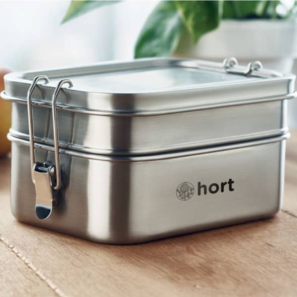 Lunchbox with logo DOUBLE CHAN Stainless steel lunchbox with logo. 2 compartments with strong and secure side buckles. Capacity 1200 ml. Depending on the surface we can use embroidery, engraving, 360° imprint or screen print.