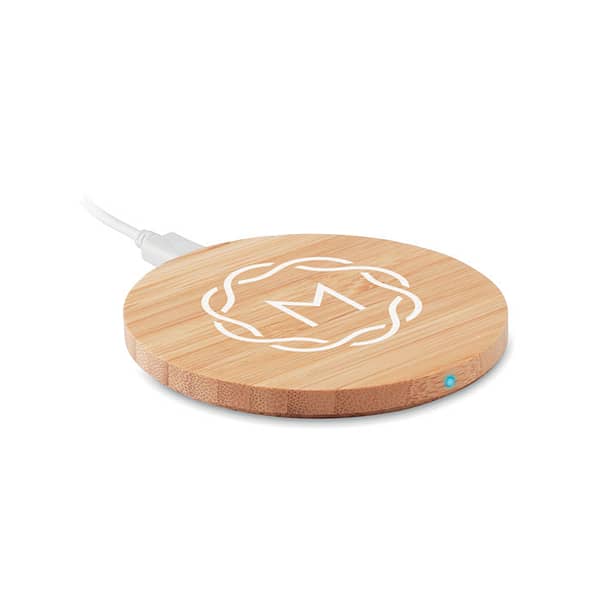 Wireless charger with logo RUNDO Wireless charger in bamboo. Blue light lit when charging.Output: DC5V/1A (5W). Connect device to your computer, place smartphone on it and allow it to charge. Compatible with all QI enabled devices such as latest Androids, iPhone® 8, X and newer. Bamboo is a natural product, there maybe slight variations in color and size per item, which can affect the final decoration outcome. Available color: Wood, Black Dimensions: Ø9X0,8 CM Height: 0.8 cm Diameter: 9 cm Volume: 0.267 cdm3 Gross Weight: 0.078 kg Net Weight: 0.046 kg Depending on the surface we can use embroidery, engraving, 360° imprint or screen print.