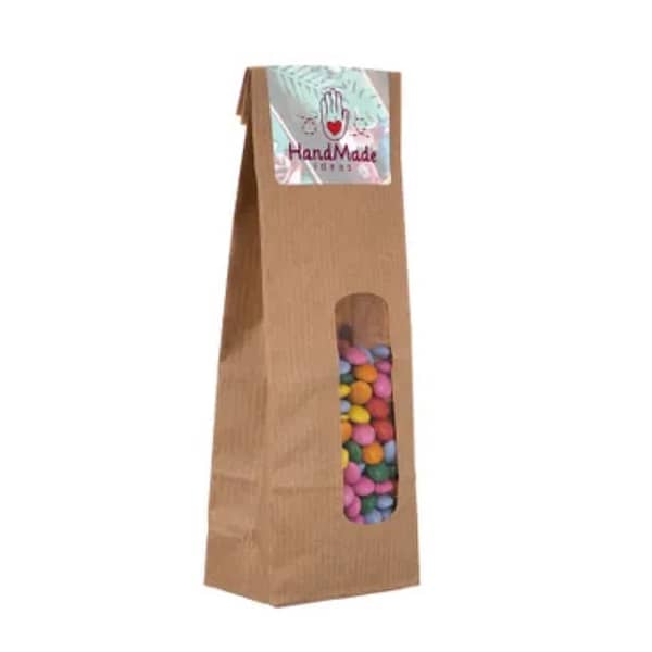 Kraft bag with sweets Taste the ultimate candy fun in our kraft bag with window! Filled with 100 grams of delicious candy, it is closed with a full-color printed sticker. Choice of various fillings. Order now and surprise someone with this tasty gift! Dimensions:Â length 5.50 centimeters - width 3.50 centimeters - height 15 centimeters Magnus Business Gifts is your partner for merchandising, gadgets or unique business gifts since 1967. Certified with Ecovadis gold!
