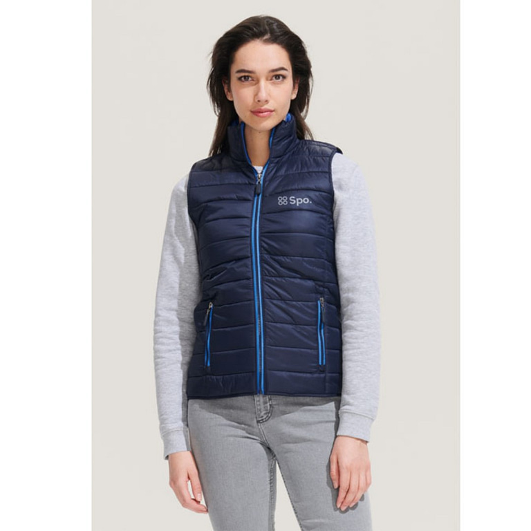 Bodywarmer with logo Wave woman Bodywarmer with logo in lightweight material. This is the sleeveless version of the popular Ride jacket but offers greater freedom of movement. Can also be used as an extra layer under a jacket. Wind and water repellent material, 2 pockets with stylish zippers and colour matched lining, high collar, stylish fit. Tone-on-tone reinforcement at the hem. Fabric details: 100% nylon. Depending on the surface we can use embroidery, engraving, 360Â° imprint or screen print.