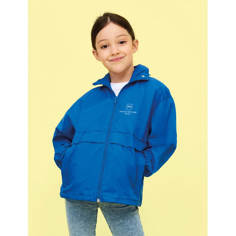 Sports jacket with logo Surf Kids Sports jacket with logo and zipper. One of the most affordable windbreakers on the market. Windproof and water repellent. Two zipped pockets, zipped neck collar to conceal the hood. Drawstring at hem, elasticated cuffs, ventilation eye. Fabric detail: 210g / m² 100% nylon 210T, Water repellent.  Sizes - 5-6 yrs: 105-116cm (XL), 7-8 yrs: 117-128cm (XXL), 9-11 yrs: 129-141cm (3XL), 12-14 yrs: 142-164cm (4XL), 15-16 yrs: 165-176 cm (5XL) Depending on the surface we can use embroidery, engraving, 360° imprint or screen print.
